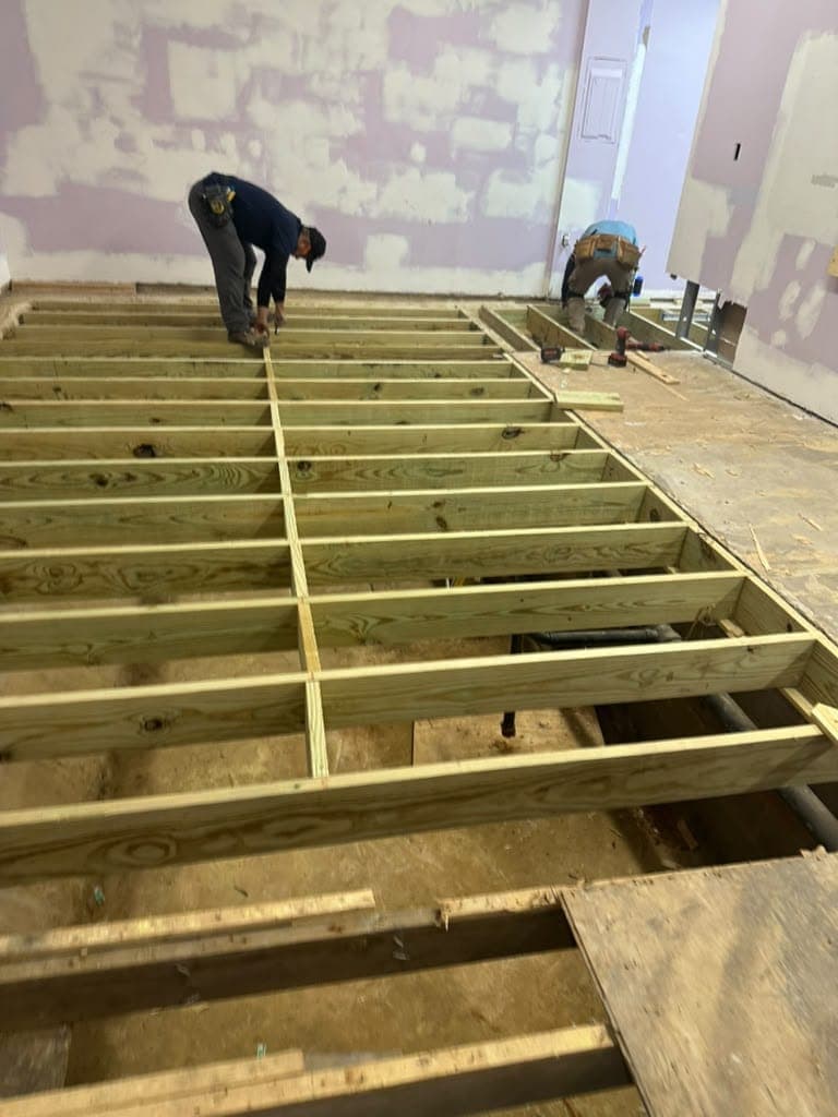 Ako Tech LLC crew installing new floor joists across a large room