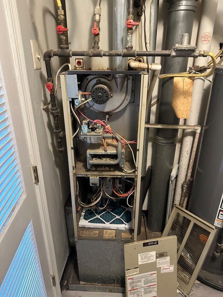 Gas furnace opened for service in a utility closet